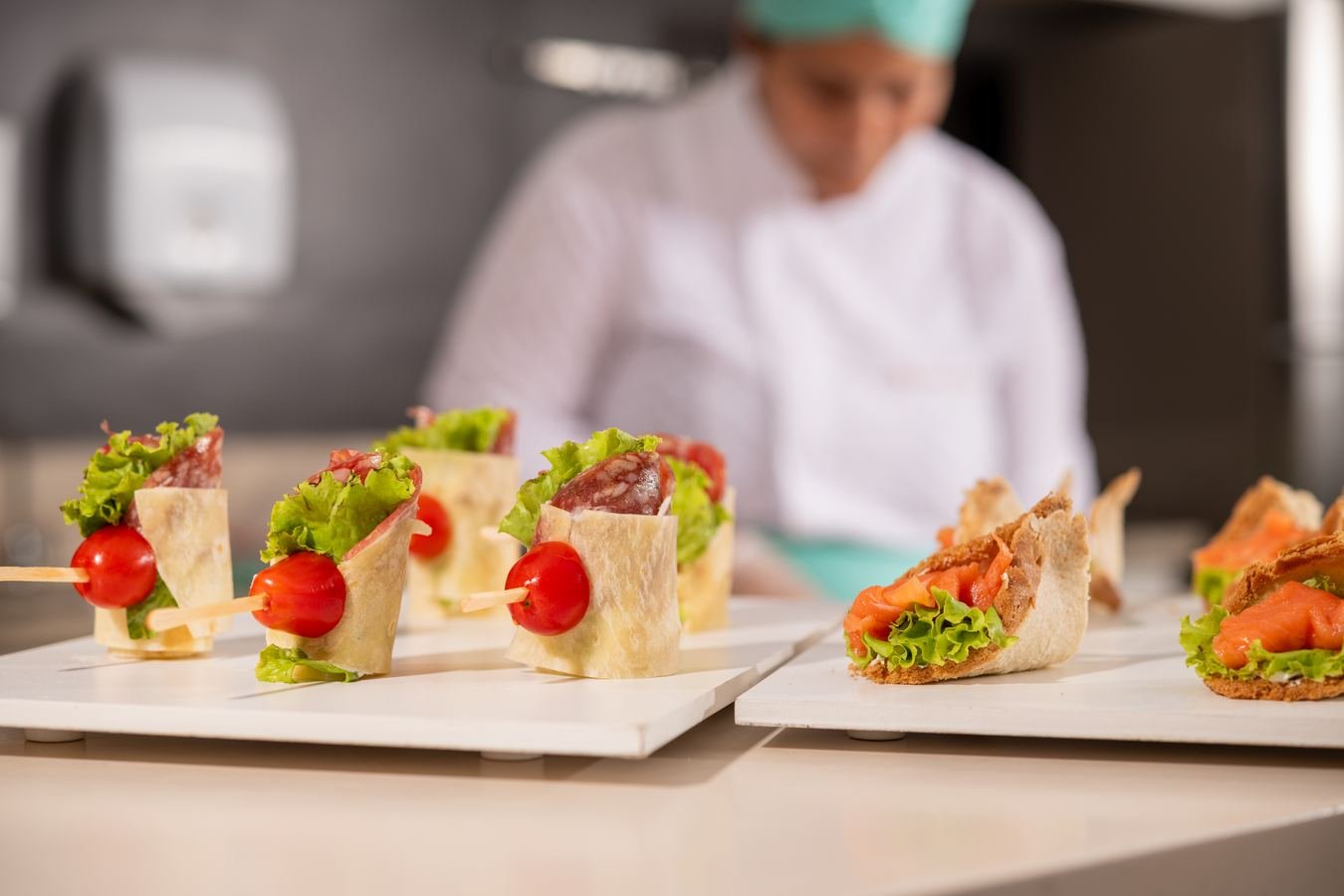Canapés de presunto cru e salmão finalizados na cozinha do Le Brunch